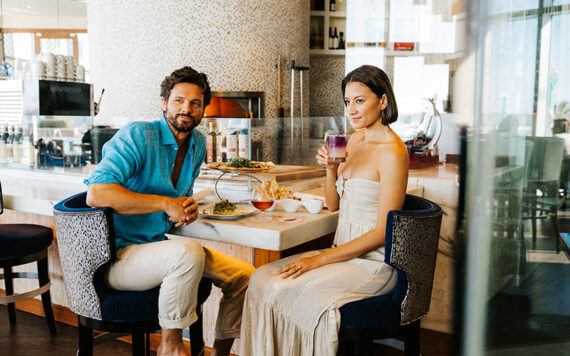 A couple dines at the bar of Sea-Guini at Opal Sands.