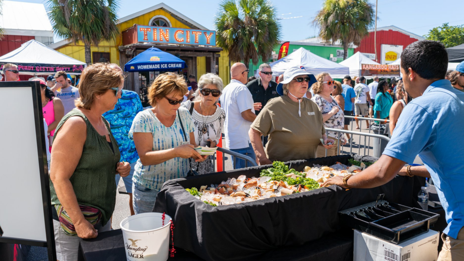 A group congregates at Tin City in Naples for the annual stone crab festival during stone crab season.