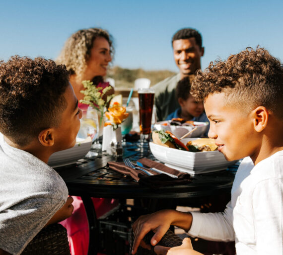 Family enjoying lunch at Tate Island Grill at Sandpearl Resort