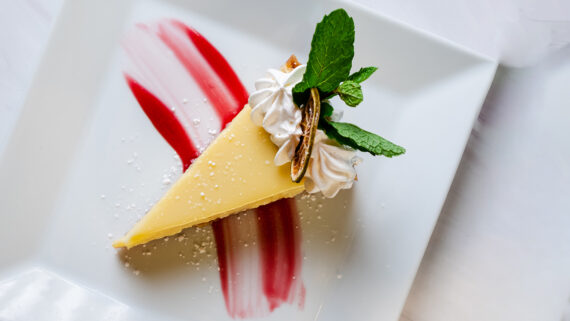 A key lime pie set on a swirl of garnish.