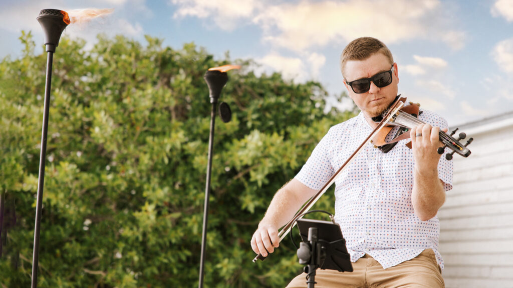 Electric violinist Matt Dendy performs on the beach at Lido Beach Resort.