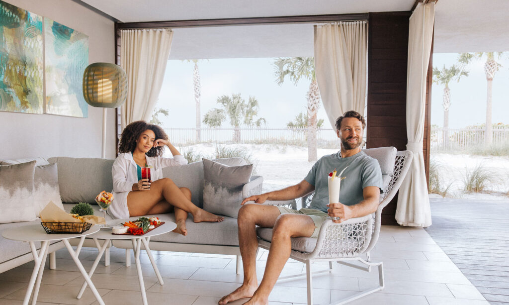 A couple sits inside one of the poolside cabanas at Zota Beach Resort.