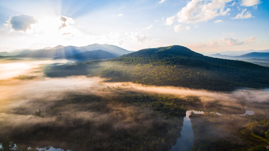 A misty sunrise spreads across the New York High Peaks Region.