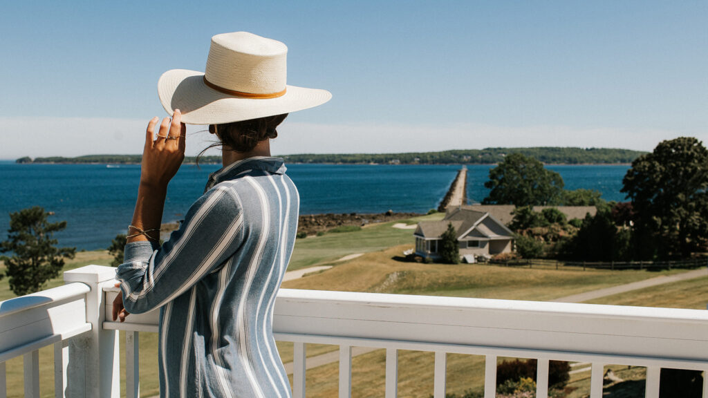 A woman staying at The Samoset looks out from her balcony to the Rockland Breakwater.