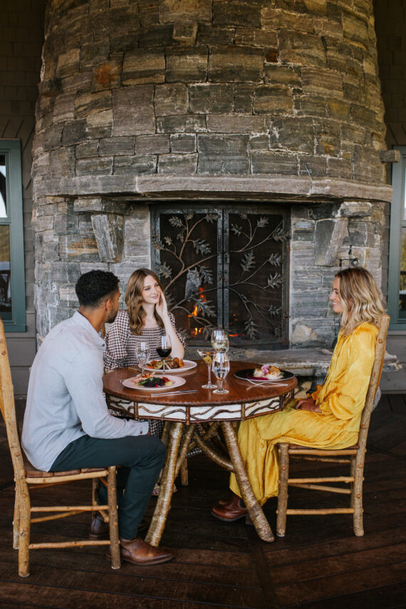 One man and two women sit around a circular table