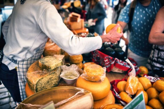 Visitors interact with a local vendor at a Farmers Market.