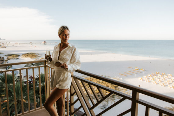 woman drinking champagne on the sandpearl gulf view suite balcony