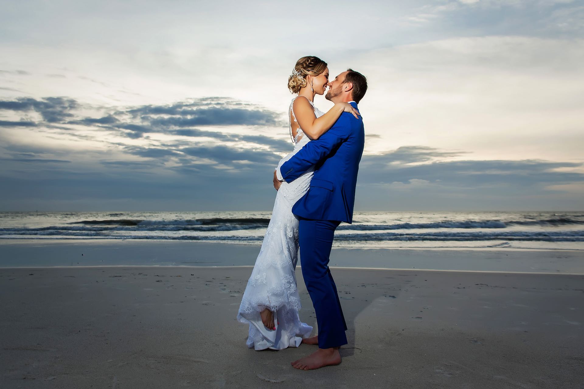 newlywed couple kissing at sandpearl beach