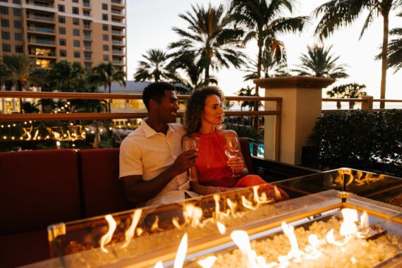 couple drinking wine fireside at sandpearl beach resort