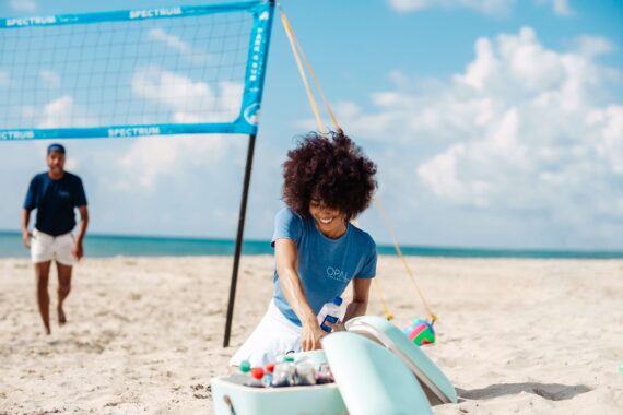 A girl grabs a drink during a beach volleyball tournament.