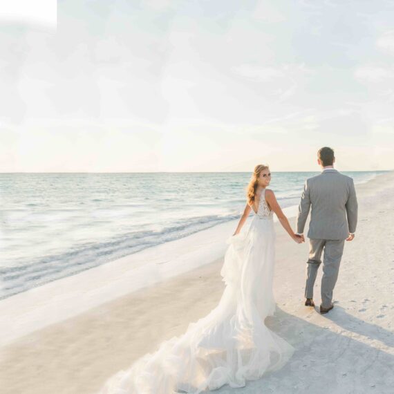newlywed couple walking on the beach