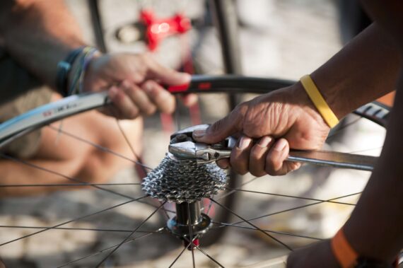 Two volunteers help to construct a bicycle for a child.