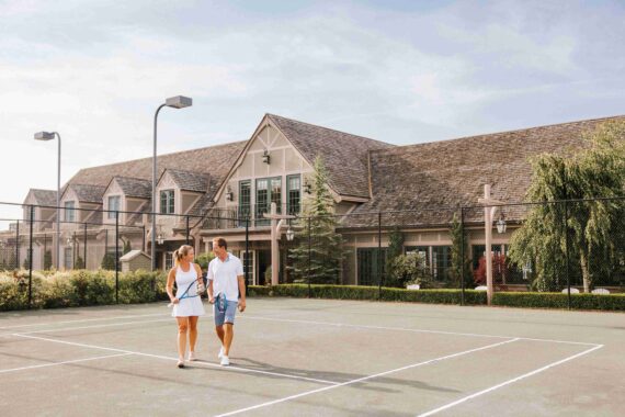 A couple walks along the tennis court at the Bar Harbor Club.