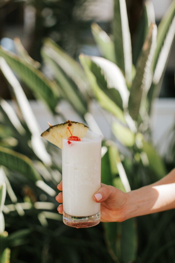 white frozen cocktail being held by a hand