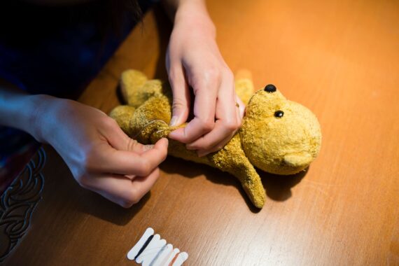 A volunteer mends a toy for a child in need.