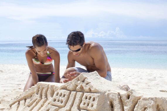A couple makes a sandcastle.