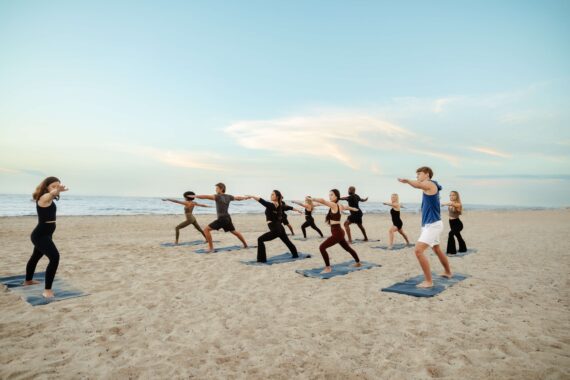 A group practices yoga on the beach.