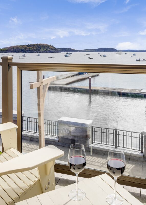 Two wine glasses placed on a small table overlooking Frenchman Bay at Harborside Hotel.