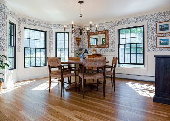 The spacious Kitchen at The Willow House is surrounded by windows and a chandelier above the table.