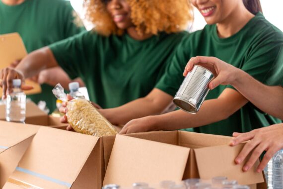 Volunteers organize cans of food into boxes.